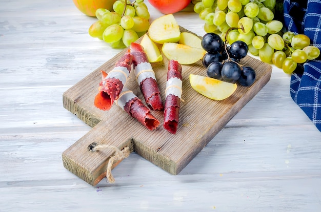 Frische ausgewählte Äpfel und Trauben und Fruchtpastille auf dunklem Hintergrund