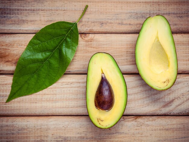 Frische Ausschnittavocado auf hölzernem Hintergrund. Organische Avocados für gesundes Lebensmittelkonzept.