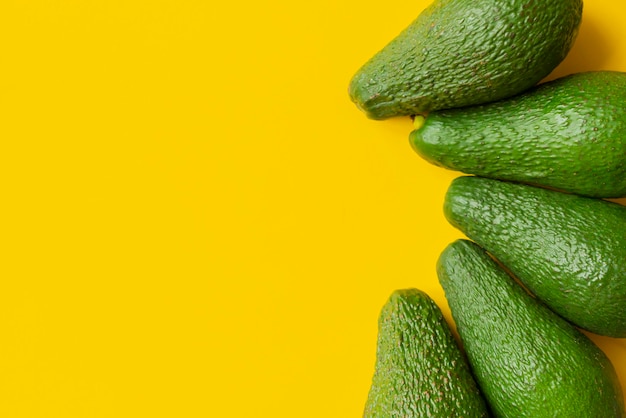 Frische Avocado auf gelbem Hintergrund isoliert Textdesign b