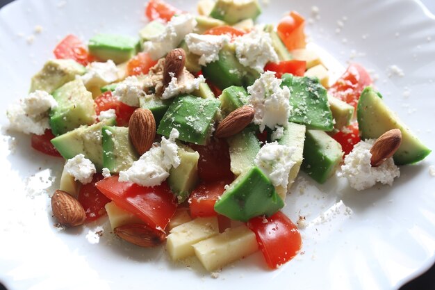 Frische Avocado köstlicher mediterraner Salat mit Kirschtomaten und Mandeln und Feta-Käse-Parmesan