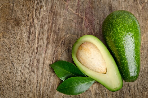 Frische Avocado mit Blättern auf Holz