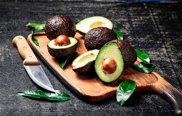 Frische Avocado mit Laub auf einem Schneidebrett