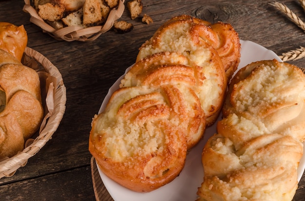 Frische Backwaren - köstliche Weidenbrötchen mit Füllung auf hölzernem Hintergrund