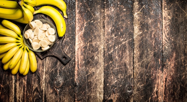 Frische Bananen mit gehackten Stücken in einer Schüssel Auf einem Holztisch