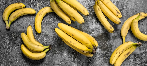 Frische Bananensträuße auf rustikalem Tisch.