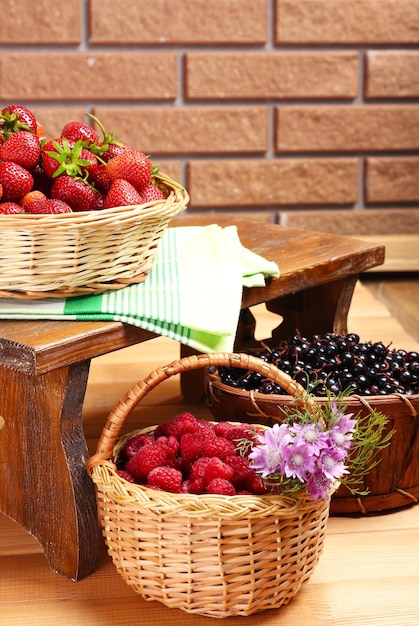 Frische Beeren in Körben auf Wandhintergrund