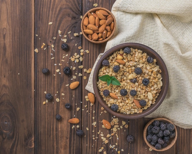 Frische Beeren, Mandeln und Müsli auf einem Holztisch