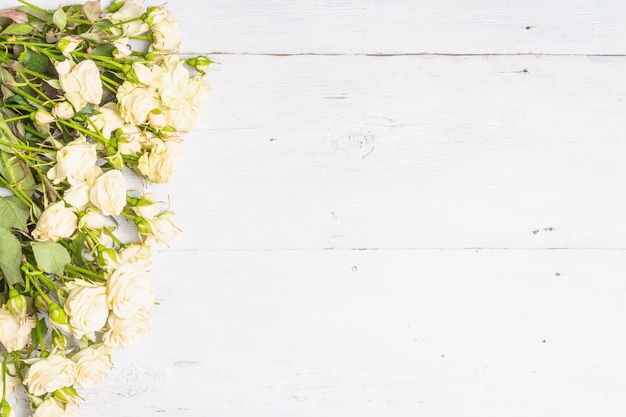 Frische beige rosen auf alten weißen holzbrettern. das festliche konzept für hochzeiten, geburtstage, 8. märz, mutter- oder valentinstag. grußkarte