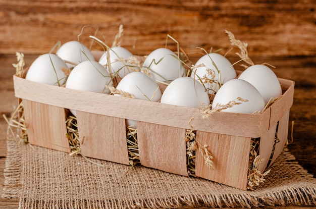 Frische Bio-Eier im Behälter auf Holzraum. Speicherplatz kopieren