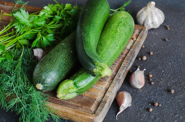 Frische bio-zucchini, knoblauch und petersilie, kräuter und gewürze.