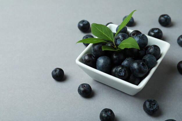 Frische Blaubeere mit Blättern auf Grau