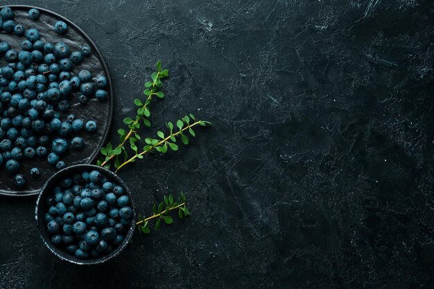 Frische Blaubeeren auf einem schwarzen Steinhintergrund Freier Kopienraum