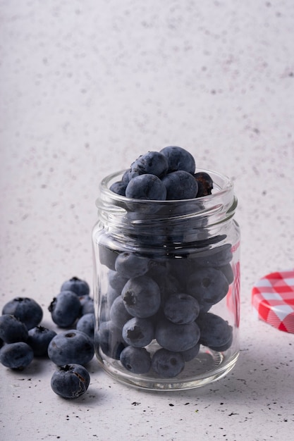 frische Blaubeeren in einem Glas auf grauem Marmor