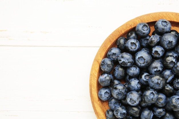 Frische Blaubeeren in einer Holzschüssel auf weißem Hintergrund Konzept des gesunden und diätetischen Essens