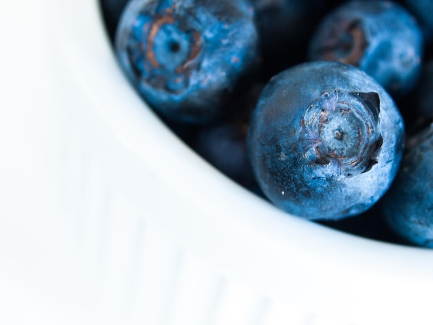 Frische Blaubeeren vom lokalen Markt auf weißem Hintergrund. Heidelbeeren enthalten Anthocyane und verschiedene sekundäre Pflanzenstoffe, die möglicherweise eine Rolle bei der Verringerung des Risikos einiger Krankheiten spielen.