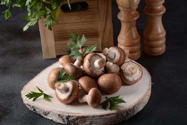 Frische braune Champignons auf Holzbrett