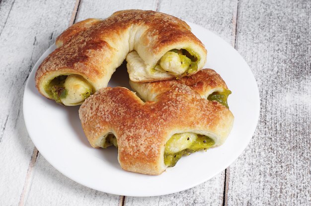 Frische Brötchen mit Kiwi-Marmelade auf altem Holztisch