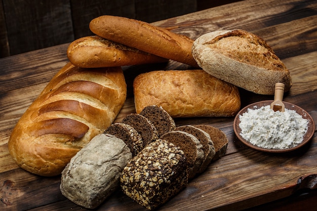 Frische Brote mit Weizen und Gluten auf einem Holztisch