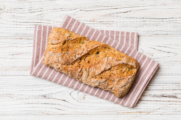 Frische Brotlaibe mit Weizen und Gluten auf einem farbigen Tischbrot auf Serviette auf rustikalem Hintergrund Draufsicht des frischen Brotes