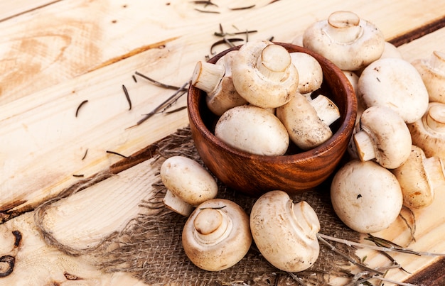 Frische Champignonpilze auf Holztisch