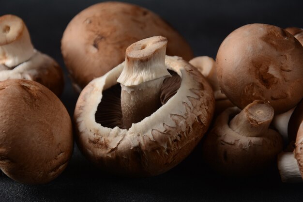 Frische Champignons auf schwarzem Hintergrund