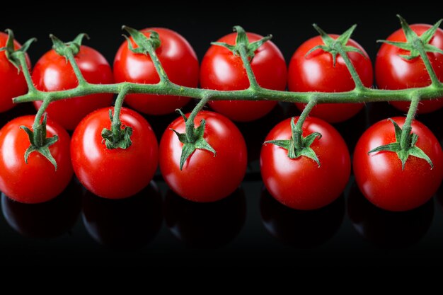 Frische Cherry-Tomaten auf schwarzem Hintergrund Bund frischer Cherry-Tomaten auf schwarzem Hintergrund