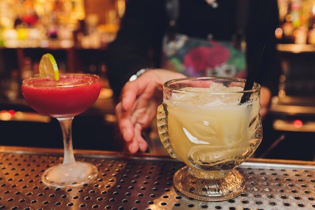 Foto frische cocktails, grüne minze und limette auf einem farbigen hintergrund verwischen das bokeh