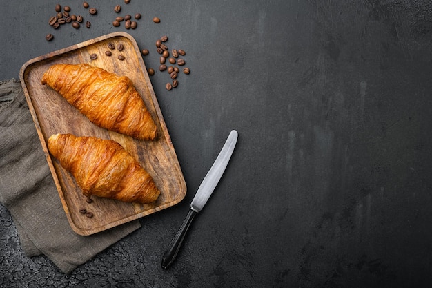 Frische Croissants auf dem Tisch auf schwarzem, dunklem Steintischhintergrund Draufsicht flach liegend mit Kopierplatz für Text