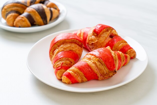 frische Croissants mit Erdbeermarmeladensauce auf Teller