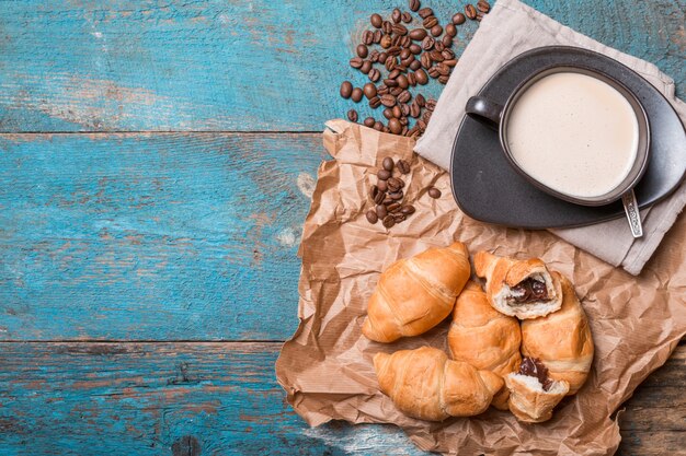 Frische Croissants und Kaffee auf Holztisch