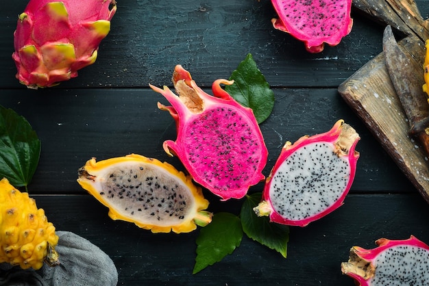 Frische Drachenfrucht auf schwarzem Hintergrund Tropische Früchte Draufsicht Freier Platz für Text