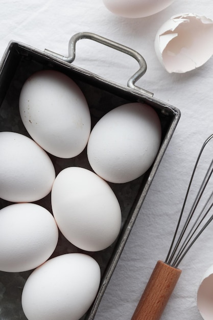 Frische Eier Eierschalen und Schneebesen zum Schlagen