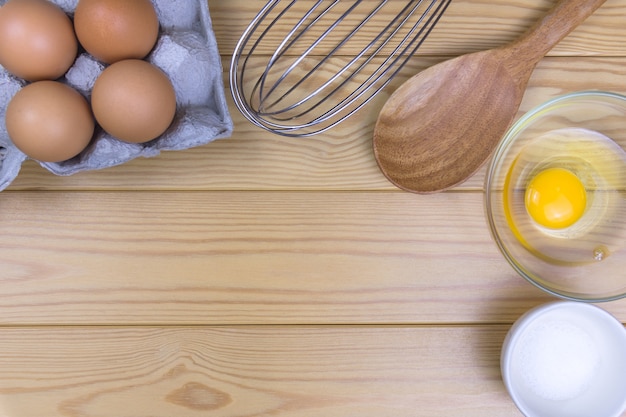 Frische Eier und Klopfer auf dem Küchentisch, Draufsicht gesundes Frühstücksproteinkonzept.