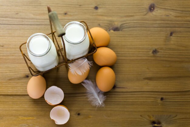 Foto frische eier und milch vom bauernhof auf holztisch.