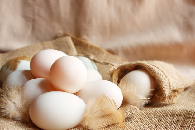 Frische Enteneier und Feder auf Sackleinen