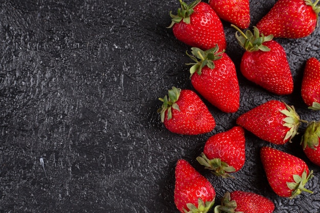 Frische Erdbeeren auf dem schwarzen Tisch