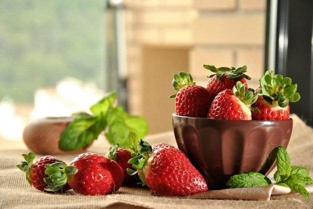 Frische Erdbeeren auf einer Platte und einem braunen Gewebe