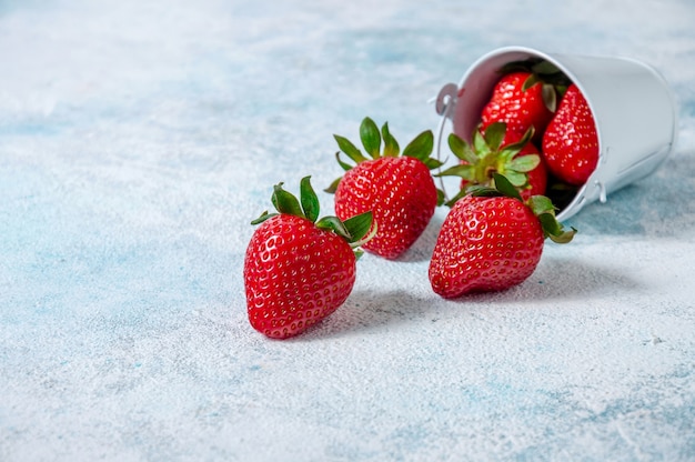 Frische Erdbeeren im kleinen weißen Eimerbrett.