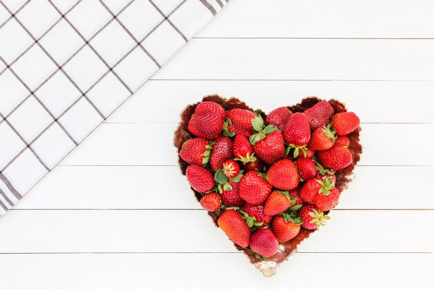 Frische Erdbeeren in der Platte auf weißem Holztisch.