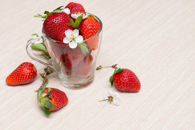 Frische Erdbeeren in einer Glasschale auf einem Holztisch