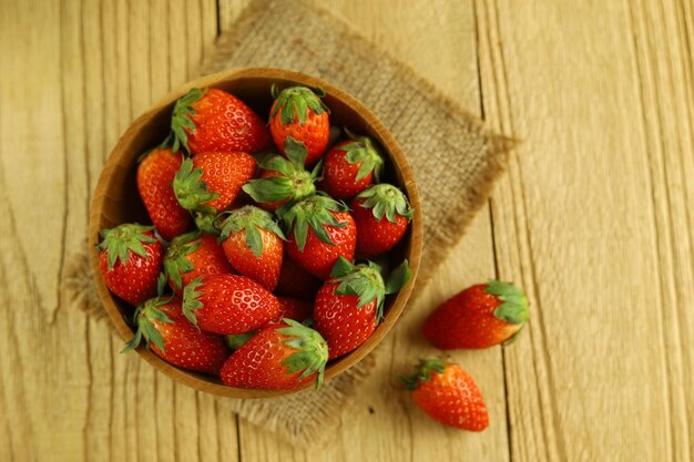 Frische Erdbeeren in einer Holzschale auf Holztisch