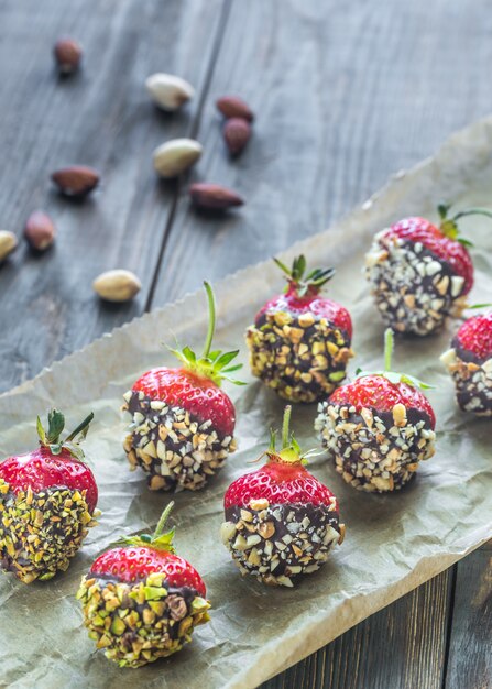 Frische Erdbeeren mit dunkler Schokolade und Nüssen bedeckt