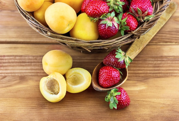 Frische Erdbeeren und Aprikosen in einem Korb