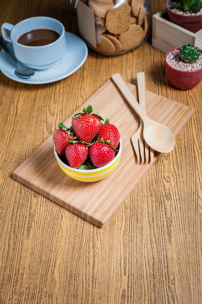 Foto frische erdbeeren und saft auf holztisch. flach legen.