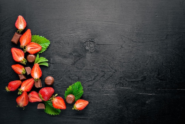 Frische Erdbeeren und Schokolade Gesundes Essen auf hölzernem Hintergrund Draufsicht Freier Speicherplatz