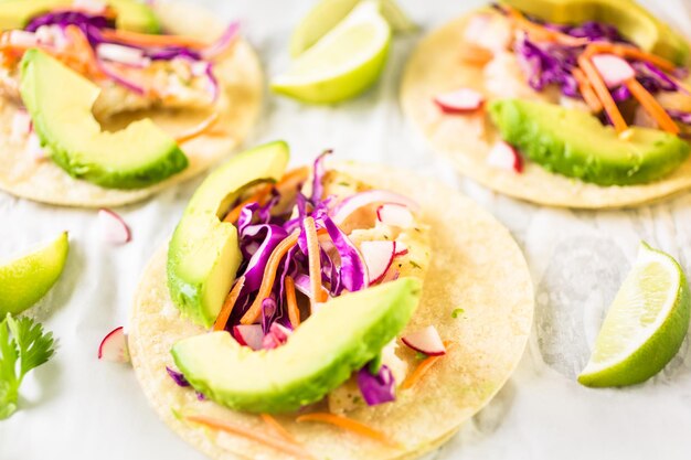 Frische Fischtacos mit Kabeljau und Purpurkohl auf weißen Maistortillas.