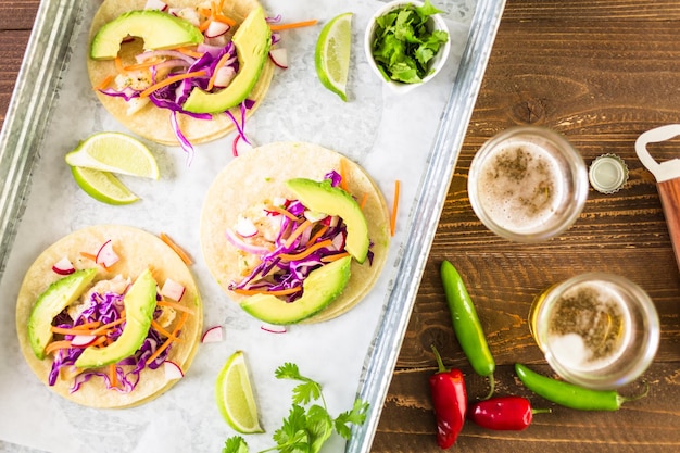 Frische Fischtacos mit Kabeljau und Purpurkohl auf weißen Maistortillas.