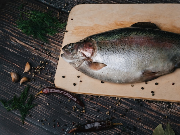 Frische Forelle auf einem Brett auf einem Holztisch für das Kochen. Roher roter Fisch