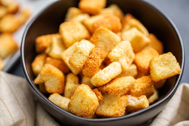 Frische French Toast Croutons in schwarzer Schüssel.