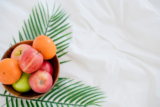 Frische Frucht auf hölzerner Schüssel auf gesundem Lebensstil des weißen Bettmorgens